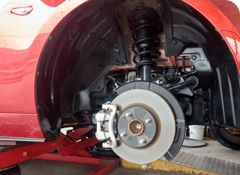 Close-up of a car's front brake system and suspension.