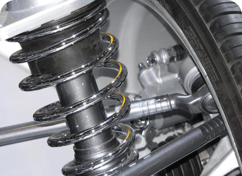 Close-up of a car suspension spring and shock absorber assembly.