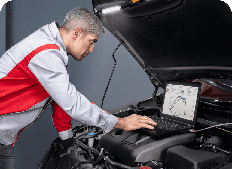 Mechanic diagnosing car engine with a digital tool under the hood.